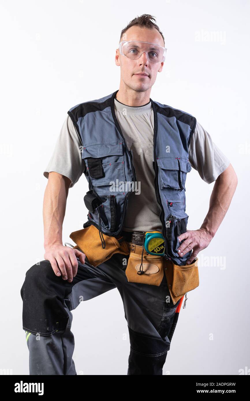 Builder in work clothes with a tool. Stock Photo