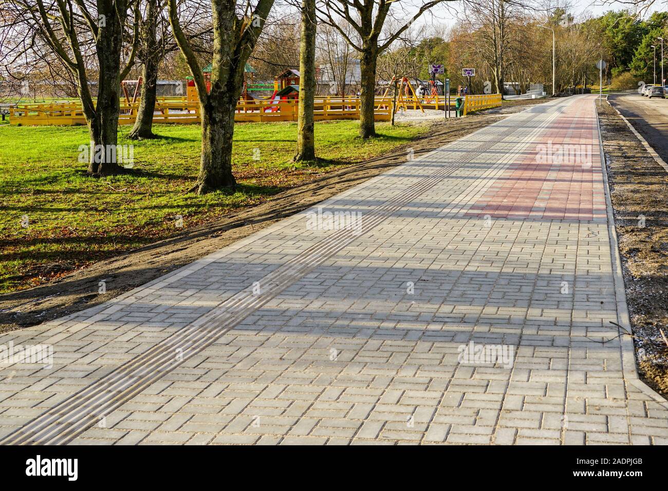 new paved walkway with bicycle lane and with guidelines for visually impaired people Stock Photo