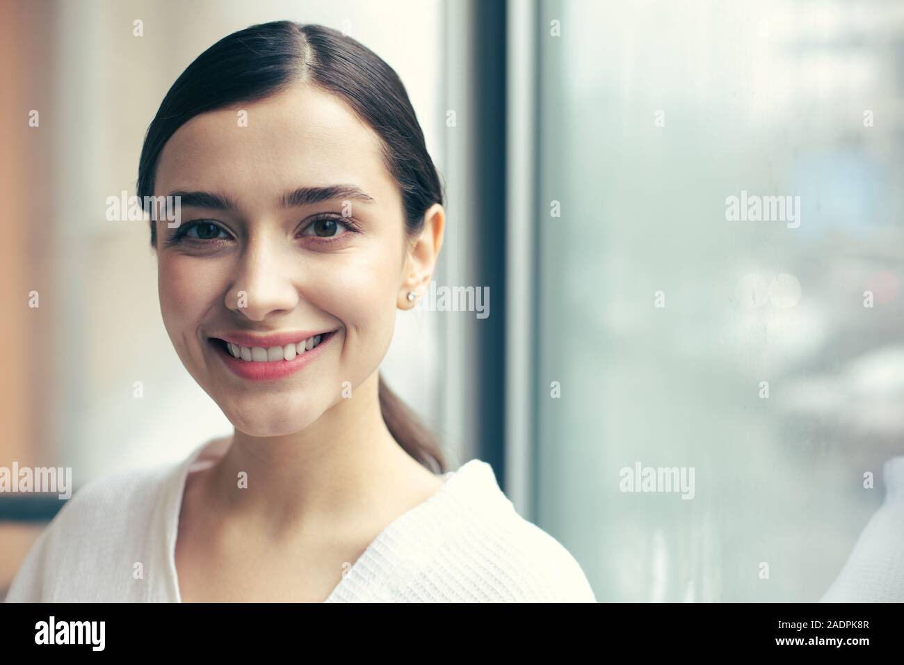 Pretty woman smiling to the camera while posing alone Stock Photo