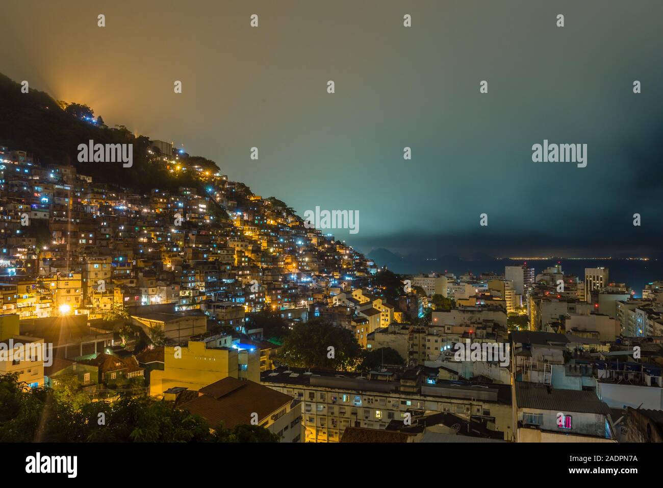 Night over Brazilian favelas on the hill with city downtown below, Rio De Janeiro, Brazil Stock Photo