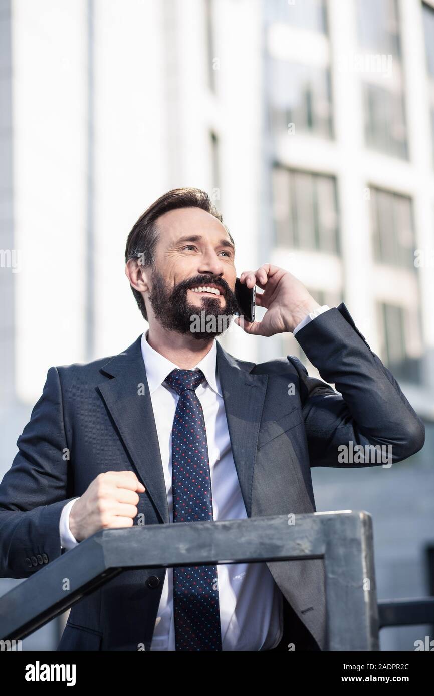 Smiling handsome businessman having a conversation on phone Stock Photo