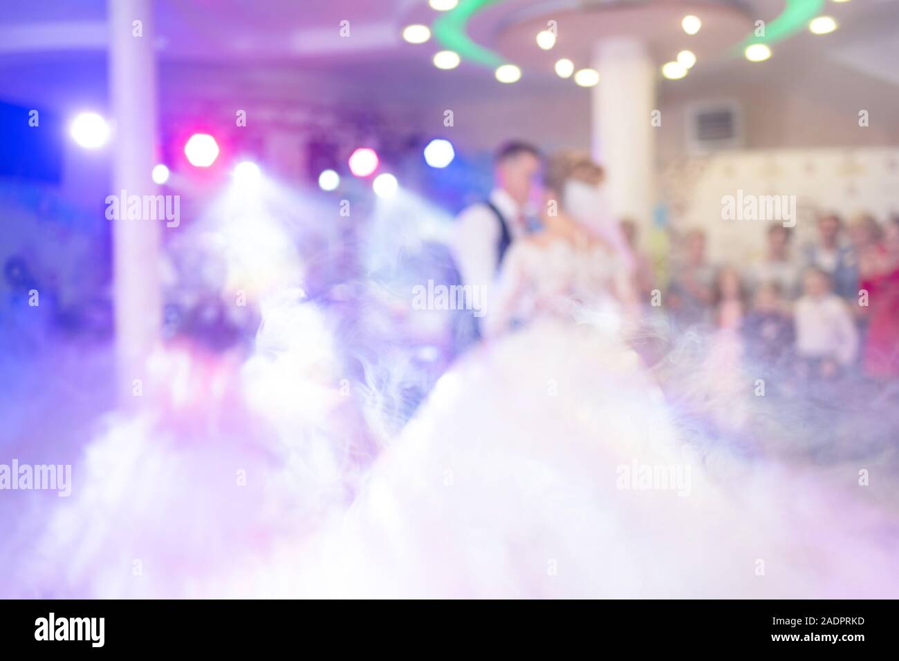 Abstract colorful blurry background. Newlyweds dance their first dance. Dance is decorated with light effects and smoke. Theme of shows organizations Stock Photo