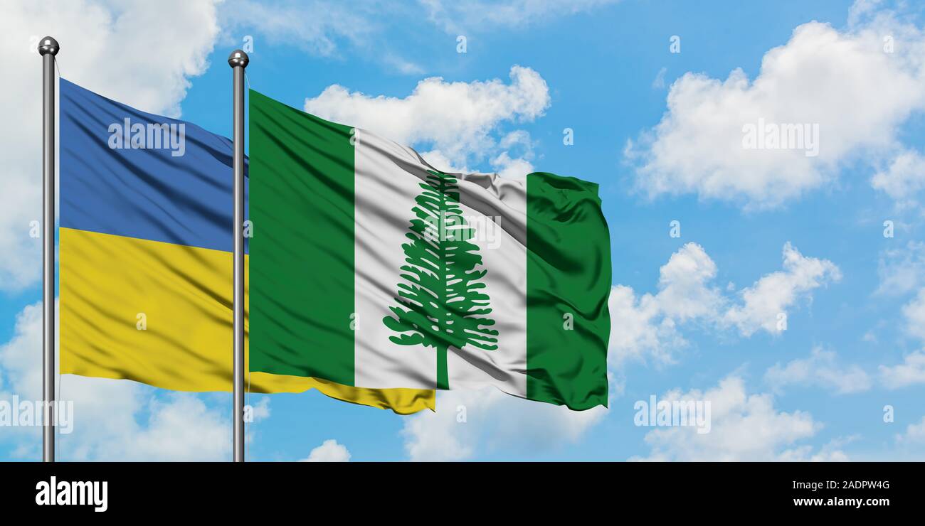 Ukraine and Norfolk Island flag waving in the wind against white cloudy blue sky together. Diplomacy concept, international relations. Stock Photo