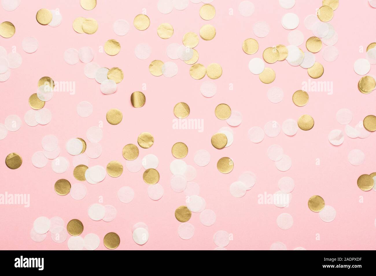 Paper confetti in pale pink, white and golden on pastel pink background, top view, selective Stock Photo