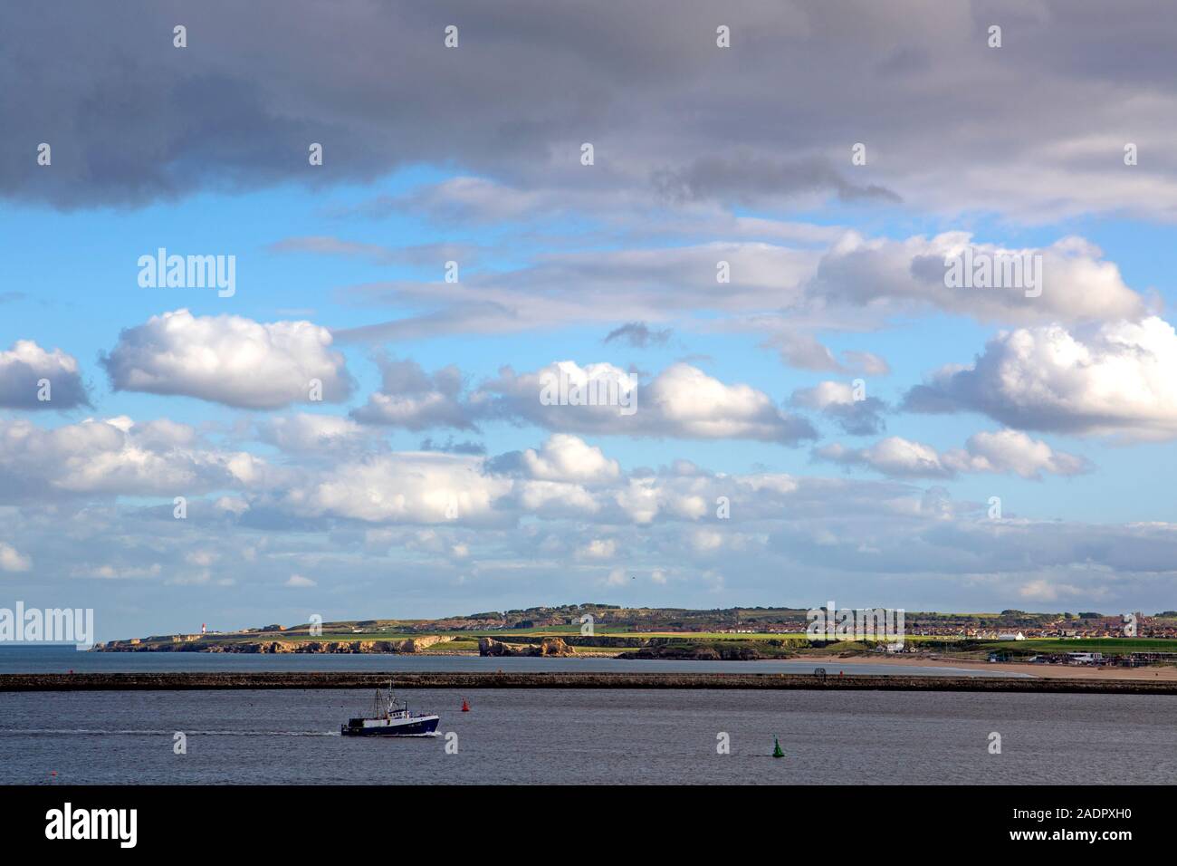Boat at the mouth of the Tyne River, with South Shields behind Stock Photo