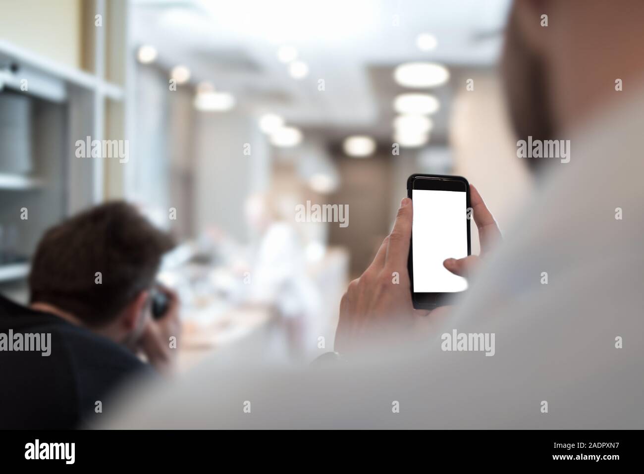 Businessman holding mobile phone in his hand trying to make a picture. Isolated cellphone screen. Stock Photo