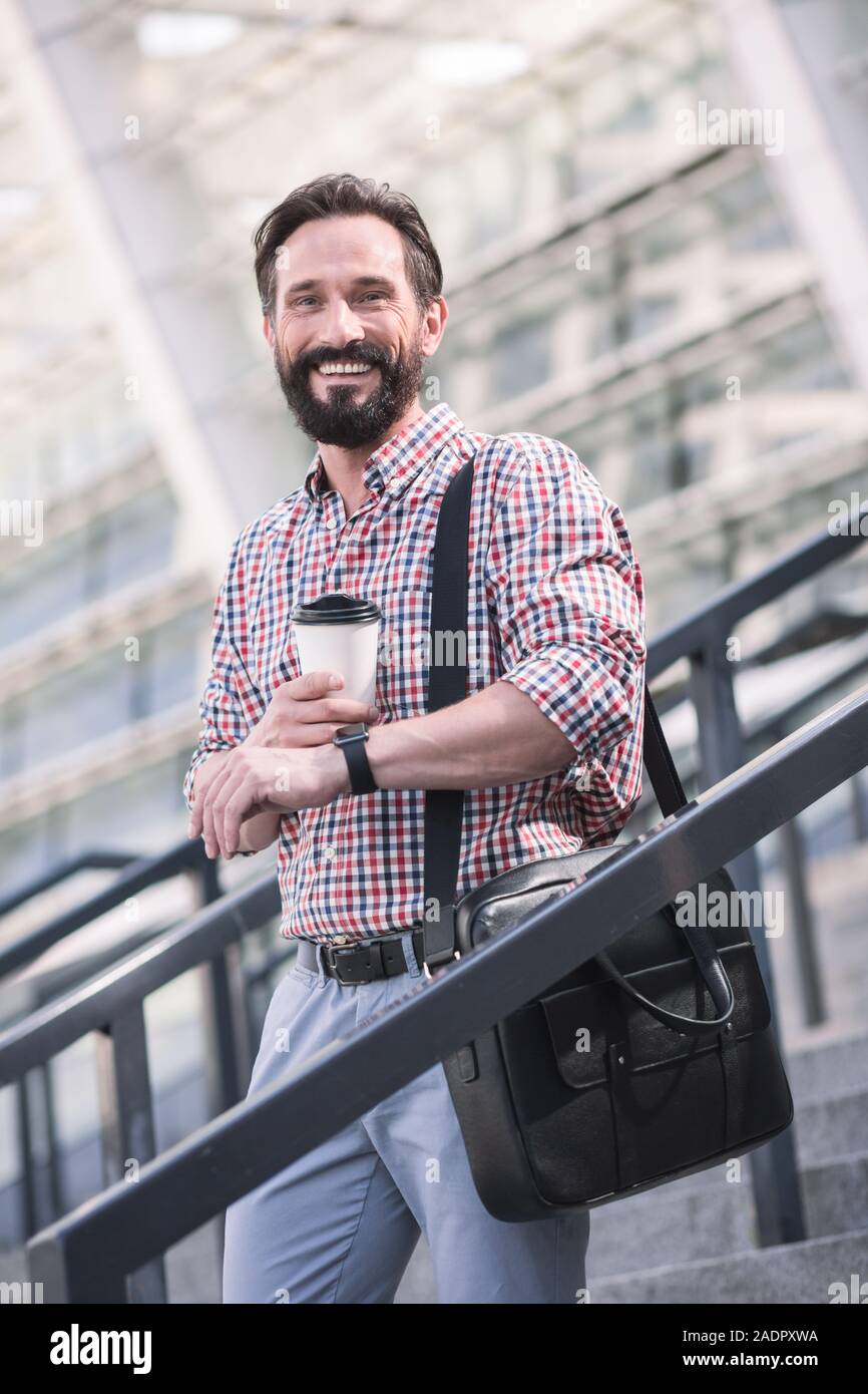 Optimistic adult man walking down the stairs outdoors Stock Photo