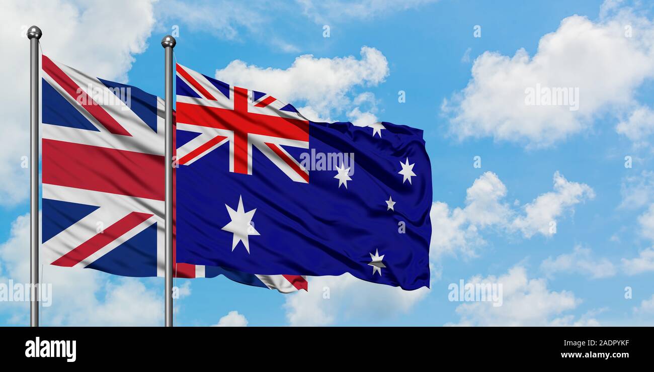 United Kingdom and Australia flag in the wind against white cloudy blue sky together. Diplomacy concept, international relations Stock - Alamy