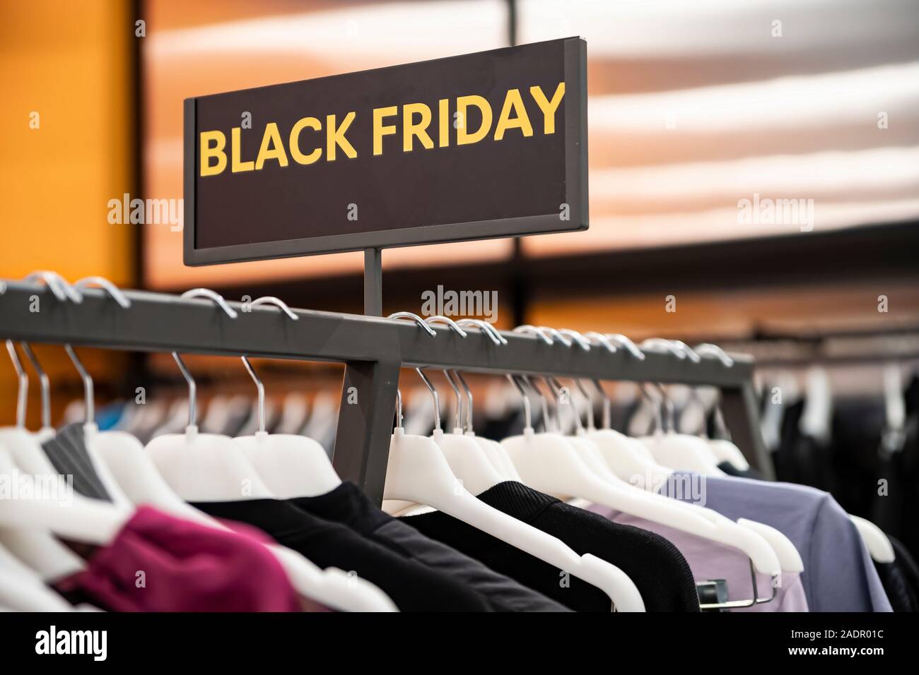 Big sale Black Friday. Discount season at the clothing store in the Mall. A  row of hangers with colorful clothes. Blurred background Stock Photo - Alamy