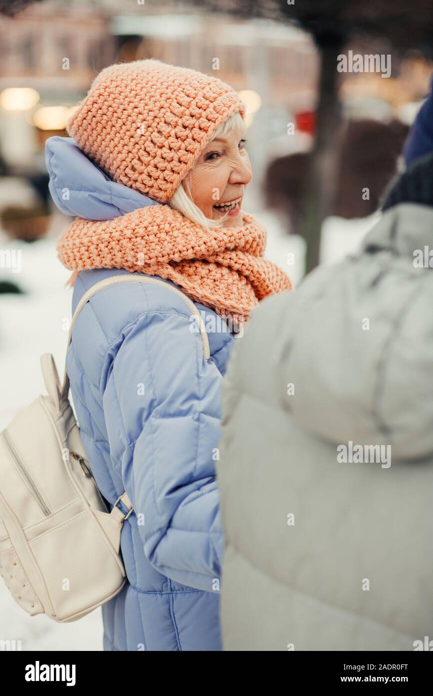 Delighted senior woman laughing while walking in winter Stock Photo
