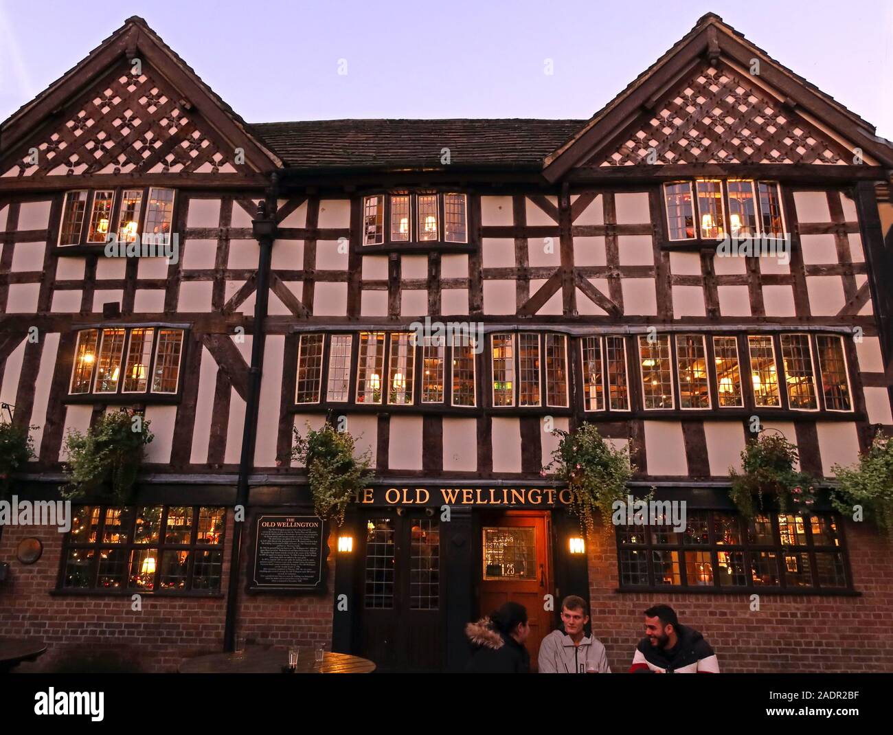 The Old Wellington,half timbered,pub from 1552,scheduled ancient monument,4 Cathedral Gates, Manchester. At dusk, winter time. Stock Photo