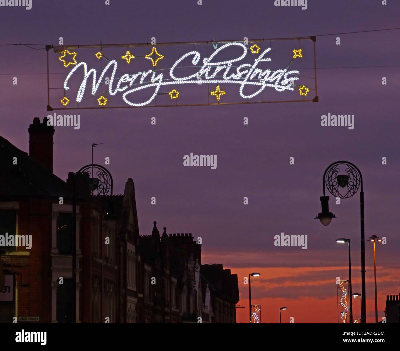 Sunset over Bridge Street Warrington, with Merry Christmas banner,Cheshire,England,UK, WA1 2QW Stock Photo