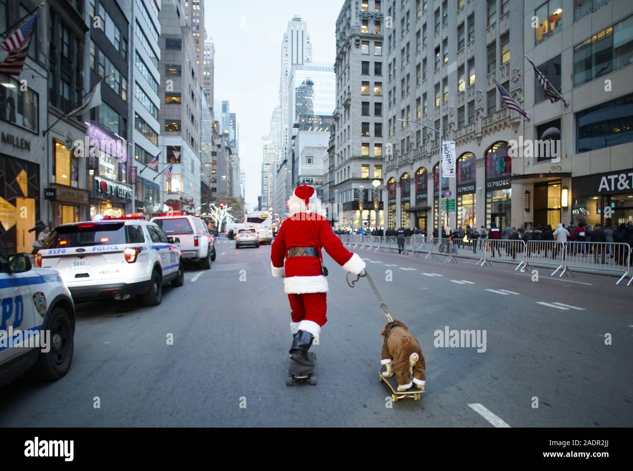 New York, United States. 04th Dec, 2019. A man dressed as Christmas Santa  Claus skateboards down 5th Avenue with a dog also on a skateboard before  the 87th annual Christmas Tree Lighting