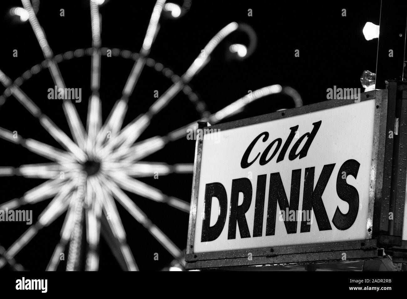A sign for cold drinks at a nighttime county fair midway. Stock Photo