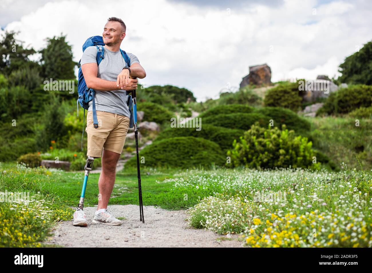 Cheerful man with prosthesis standing with Nordic walking sticks Stock Photo