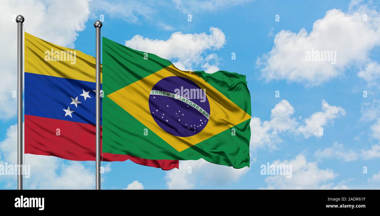 Venezuela and Brazil flag waving in the wind against white cloudy blue sky together. Diplomacy concept, international relations. Stock Photo