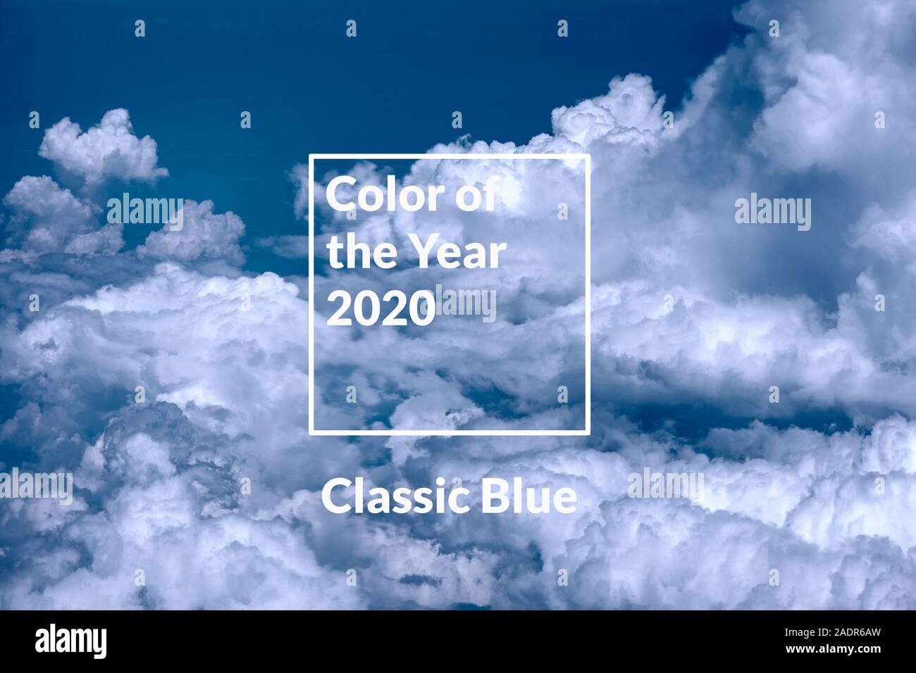 Blue sky background with white clouds toned in color of the year 2020 classic blue. Stock Photo