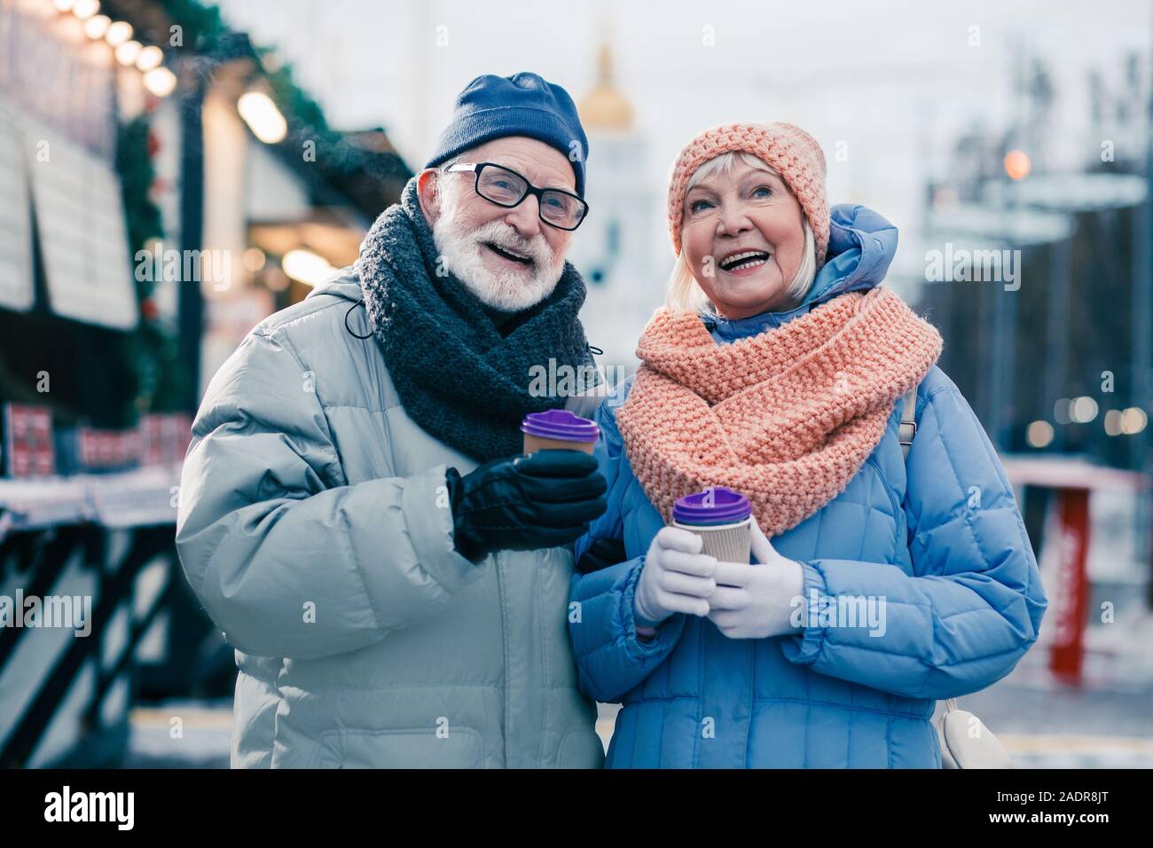 Happy aged couple being on the winter fair and smiling Stock Photo