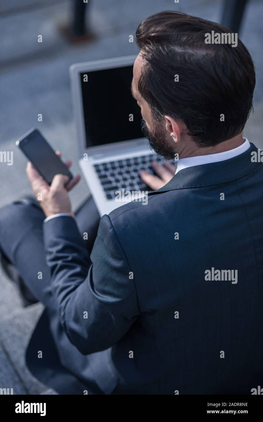 Rear view of a pleasant businessman using his phone Stock Photo