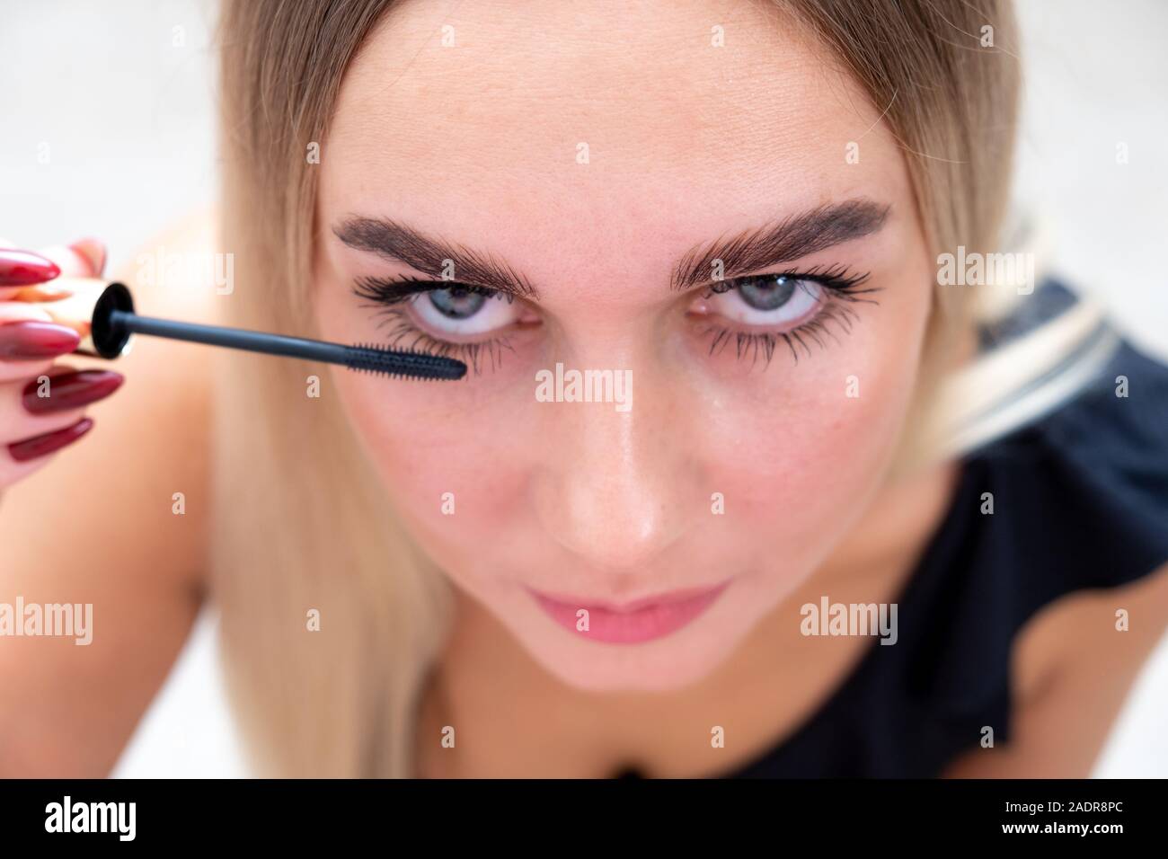 Female eyes with mascara brush. Female eyes with long eyelashes and a mascara brush Stock Photo