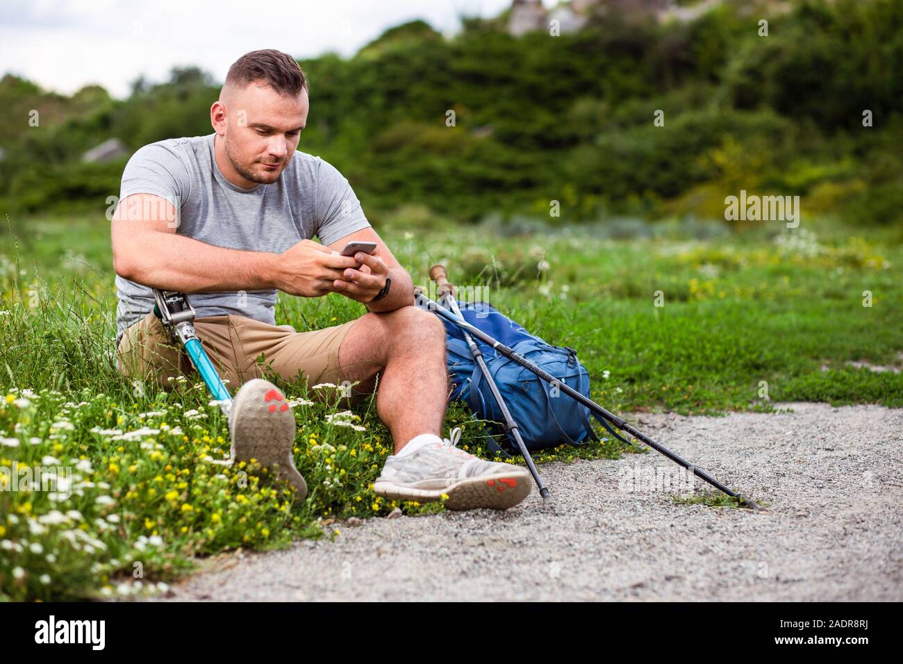 PLeasant man with prosthesis using his smartphone Stock Photo