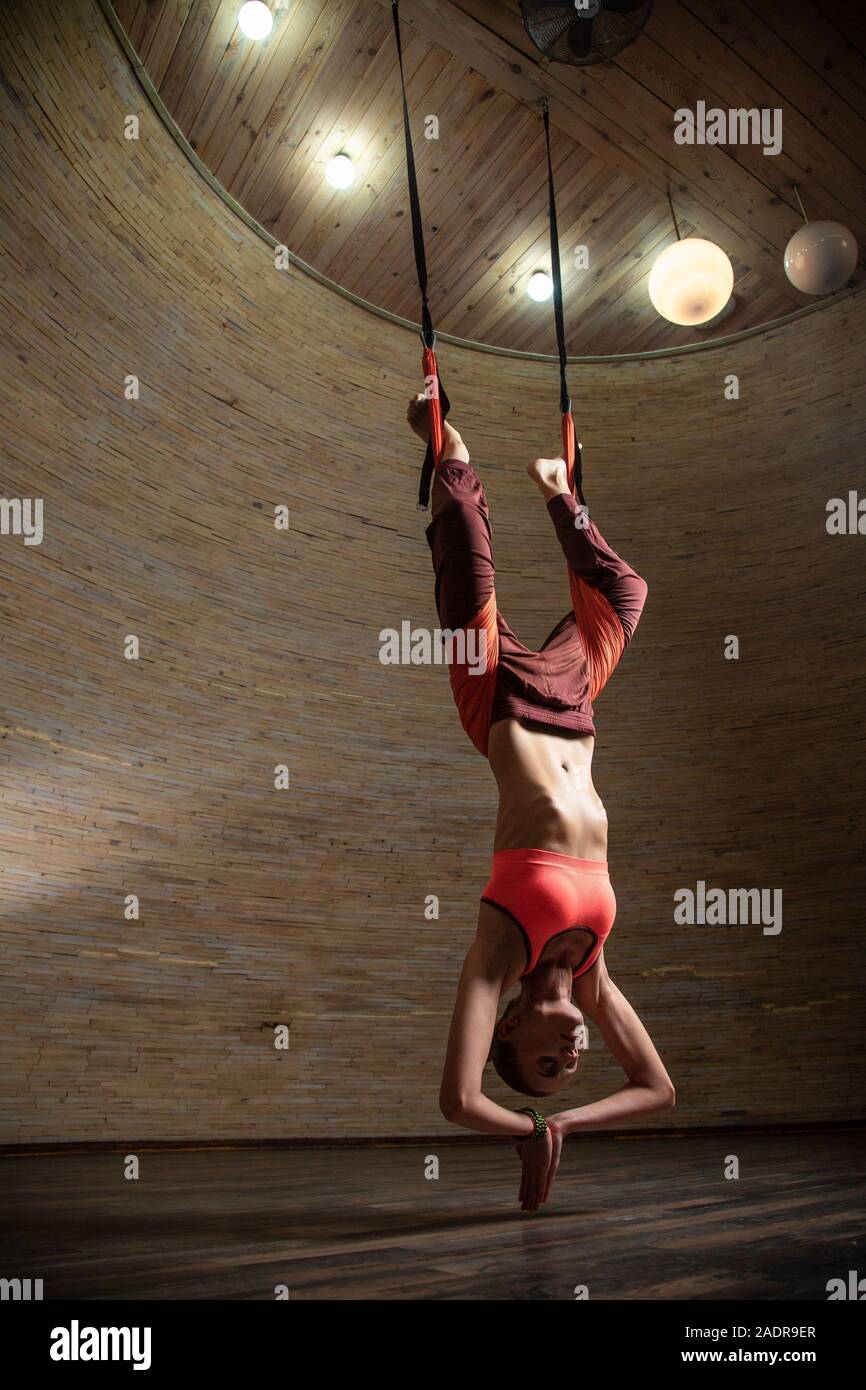 Full length of woman hanging on the aerial yoga straps Stock Photo