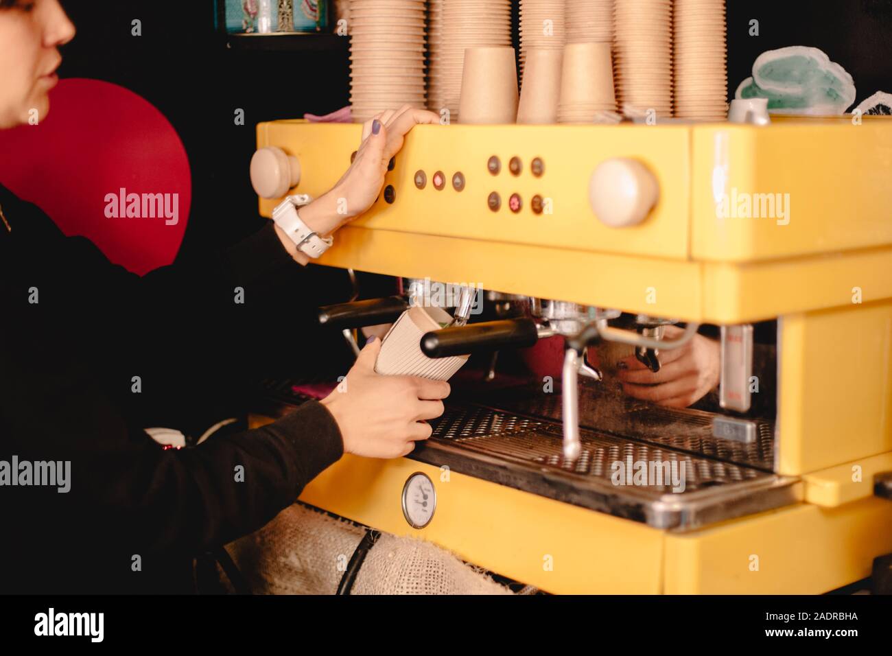Female barista preparing tea using coffee machine Stock Photo