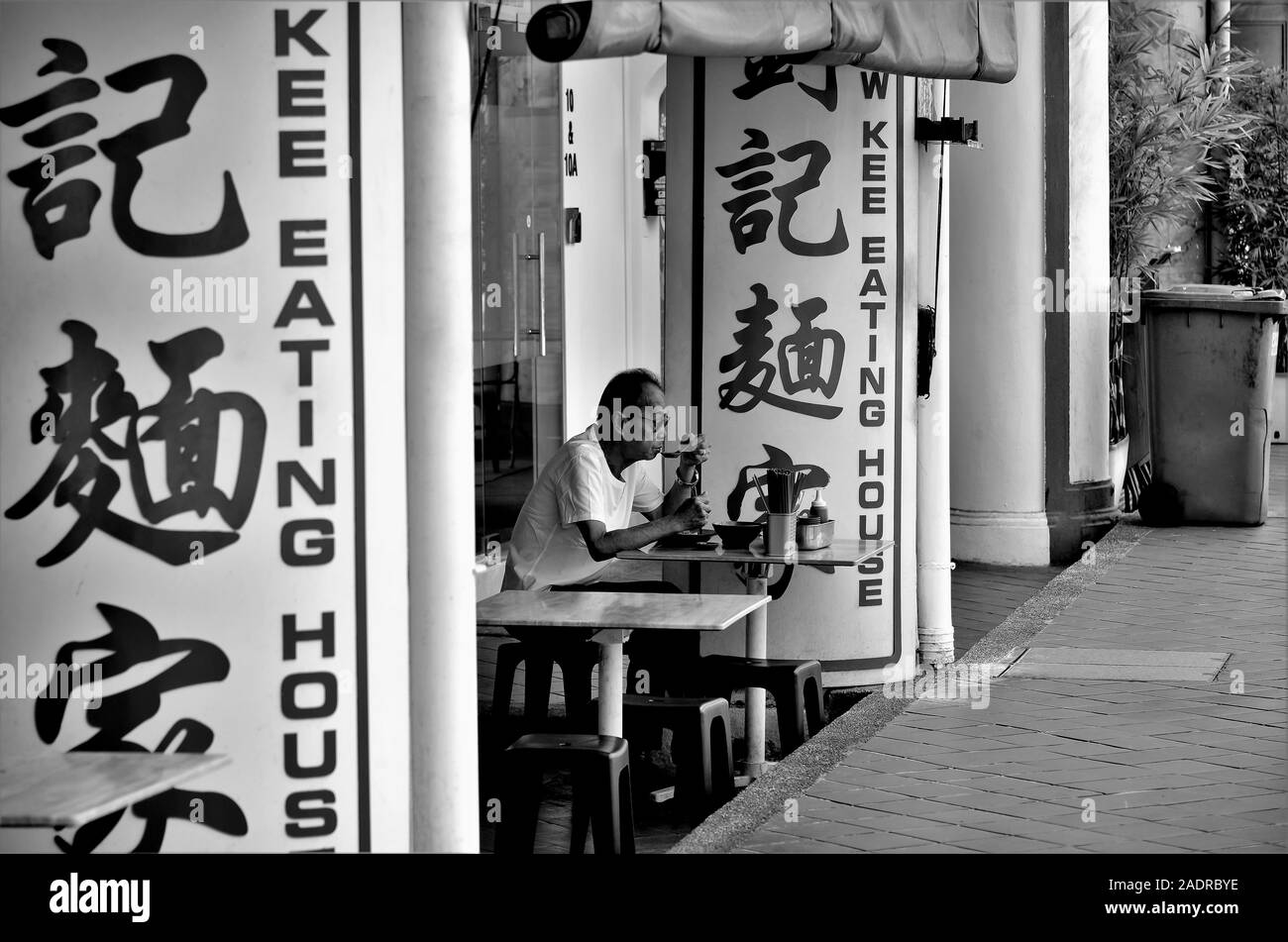 Exterior of traditional Chinese noodle restaurant in Chinatown, Singapore in monochrome and perspective view Stock Photo