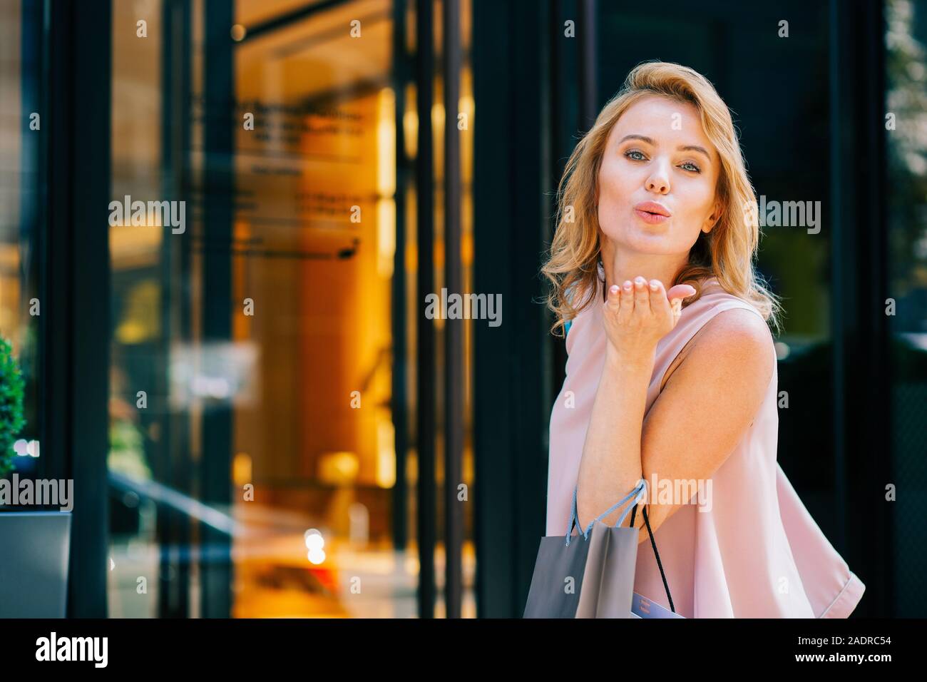 Lovely lady sending hand kiss while being outdoors Stock Photo