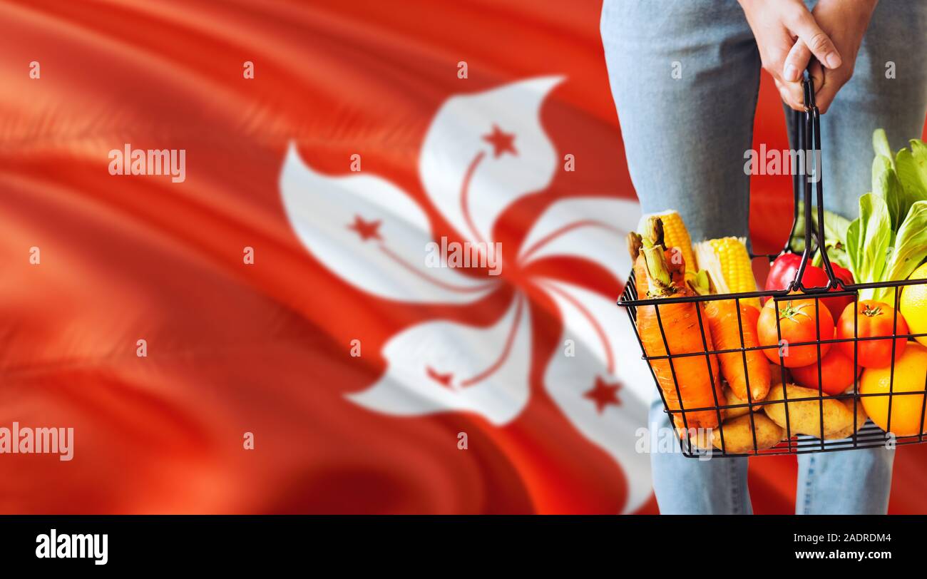 Woman is holding supermarket basket, Hong Kong waving flag background