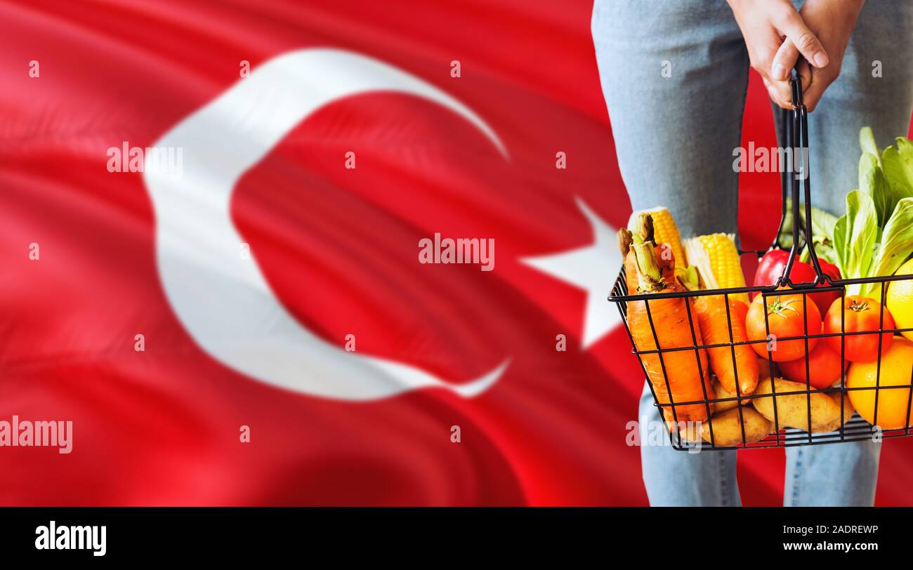 Woman is holding supermarket basket, Turkey waving flag background