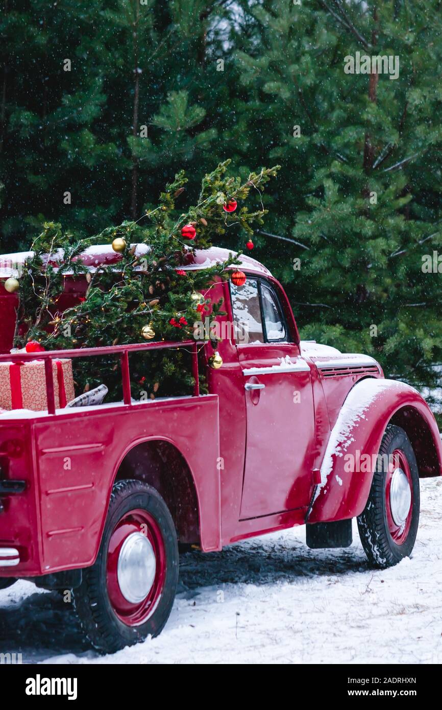 A Red Car With Christmas Decorations And A Christmas Tree Is