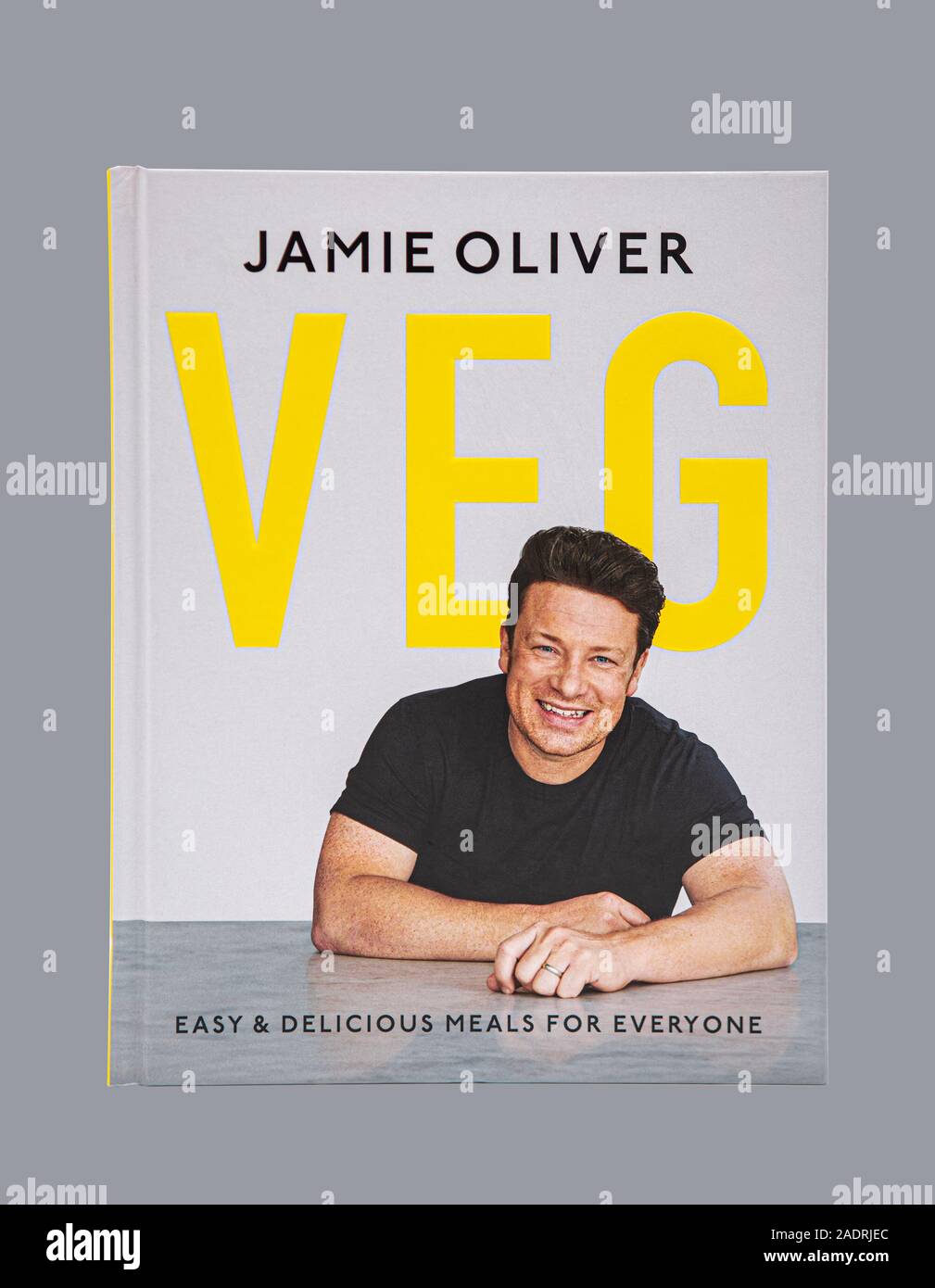 SWINDON, UK - NOVEMBER 25, 2019: Jamie Oliver Veg Cook Book, Easy and Delicious Meals for everyone on a gray background. Stock Photo