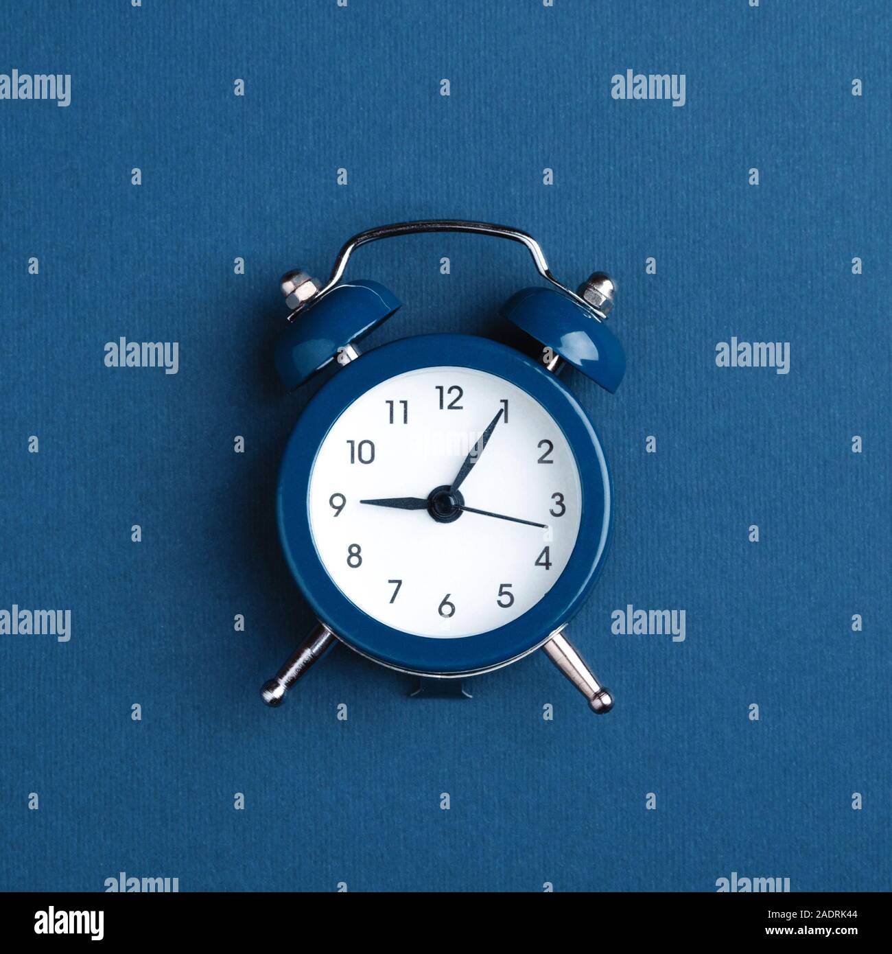 Classic alarm clock on blue background. Minimal styled photo Stock ...