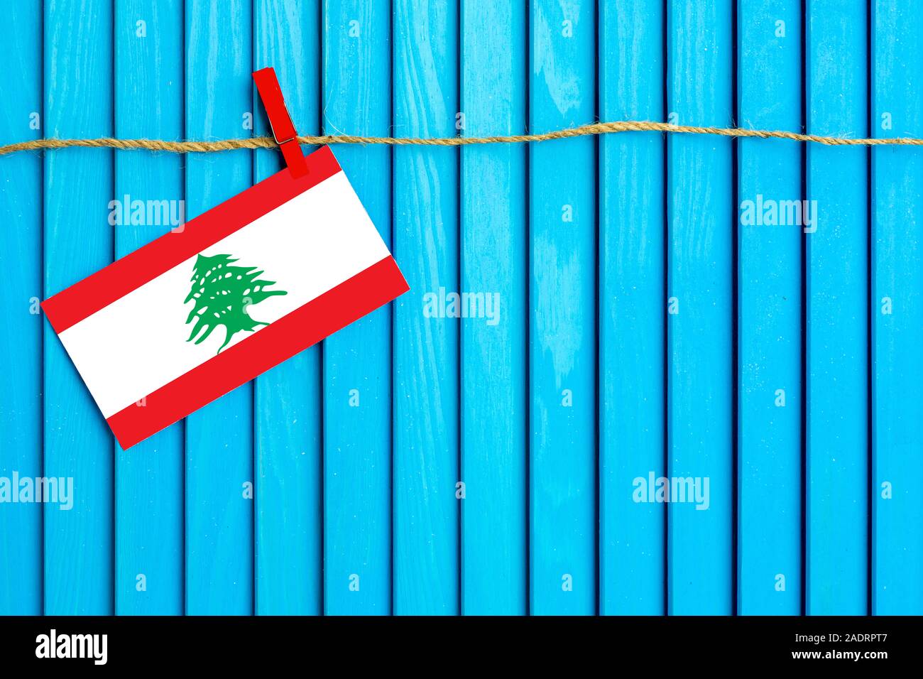 Flag of Lebanon hanging on clothesline attached with wooden clothespins