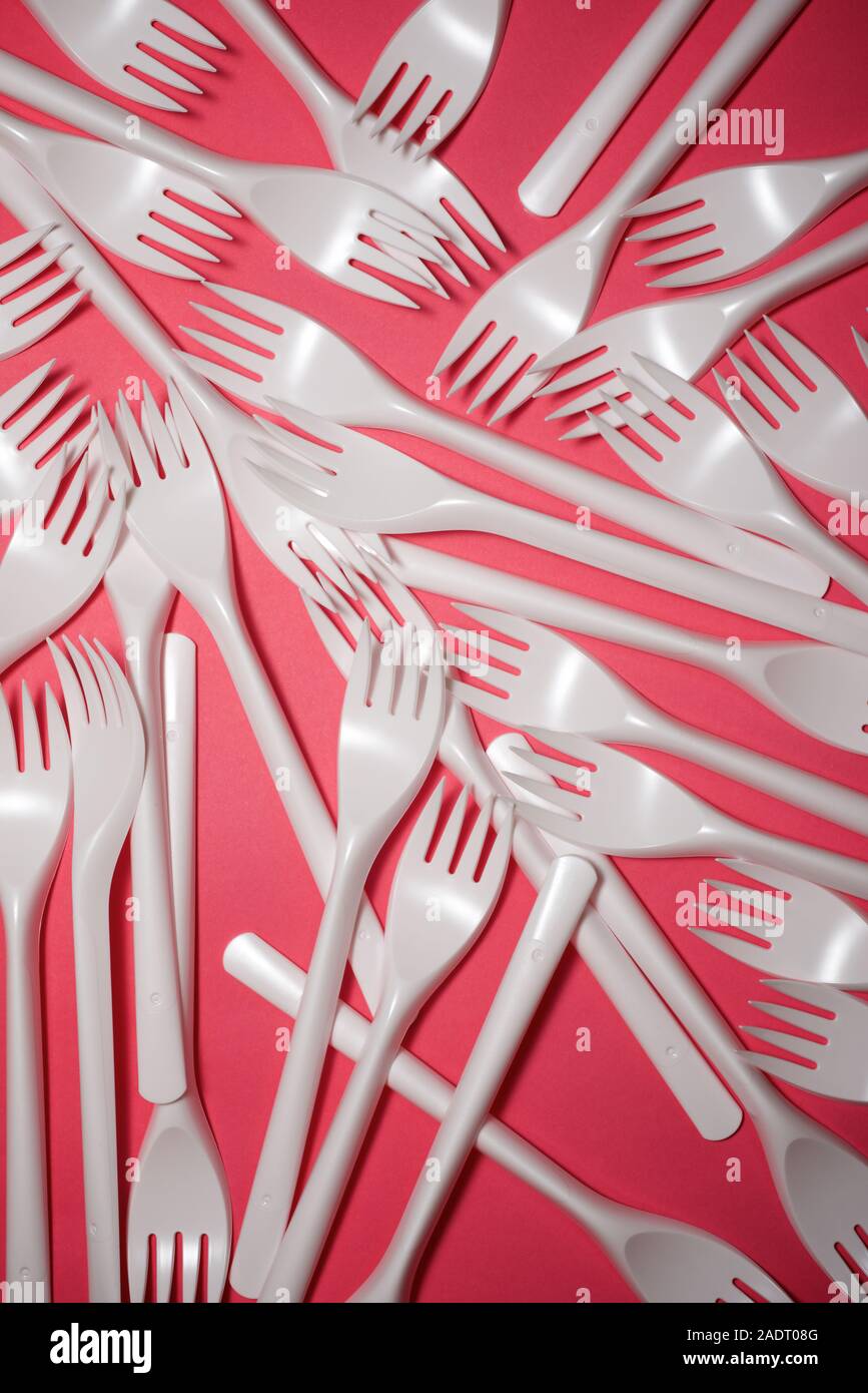 Disposable plastic cutlery on a pink table Stock Photo Alamy