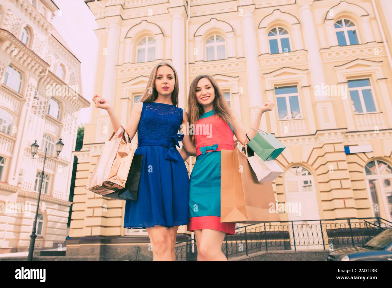 two young women with shopping bags walking in the city Stock Photo - Alamy