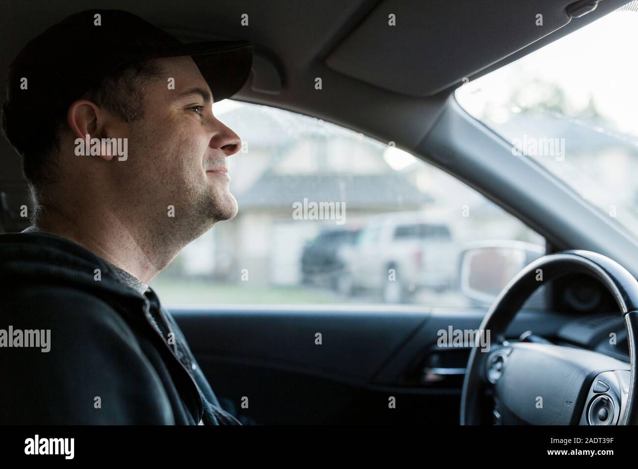 Happy white male industrial worker driving to work in car Stock Photo