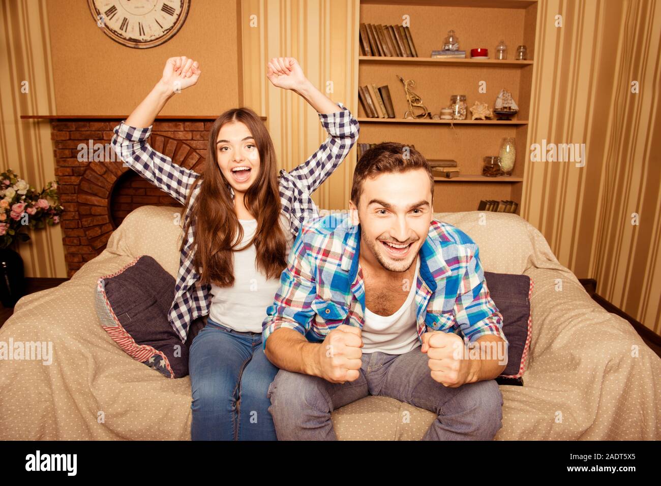 excited loving couple watching their favorite game on TV at home Stock Photo