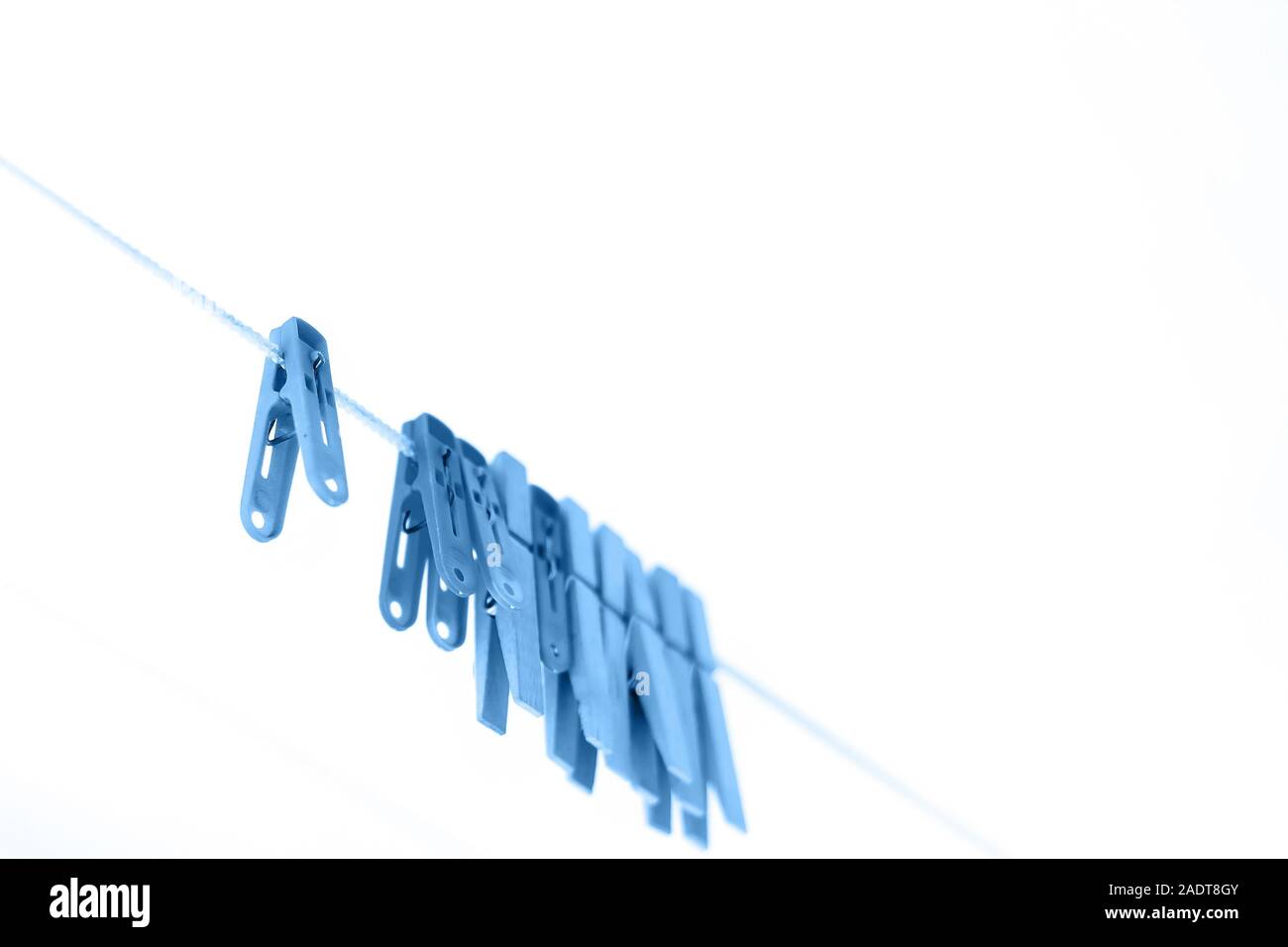 Colored clothespins on a rope on a blurred background Stock Photo