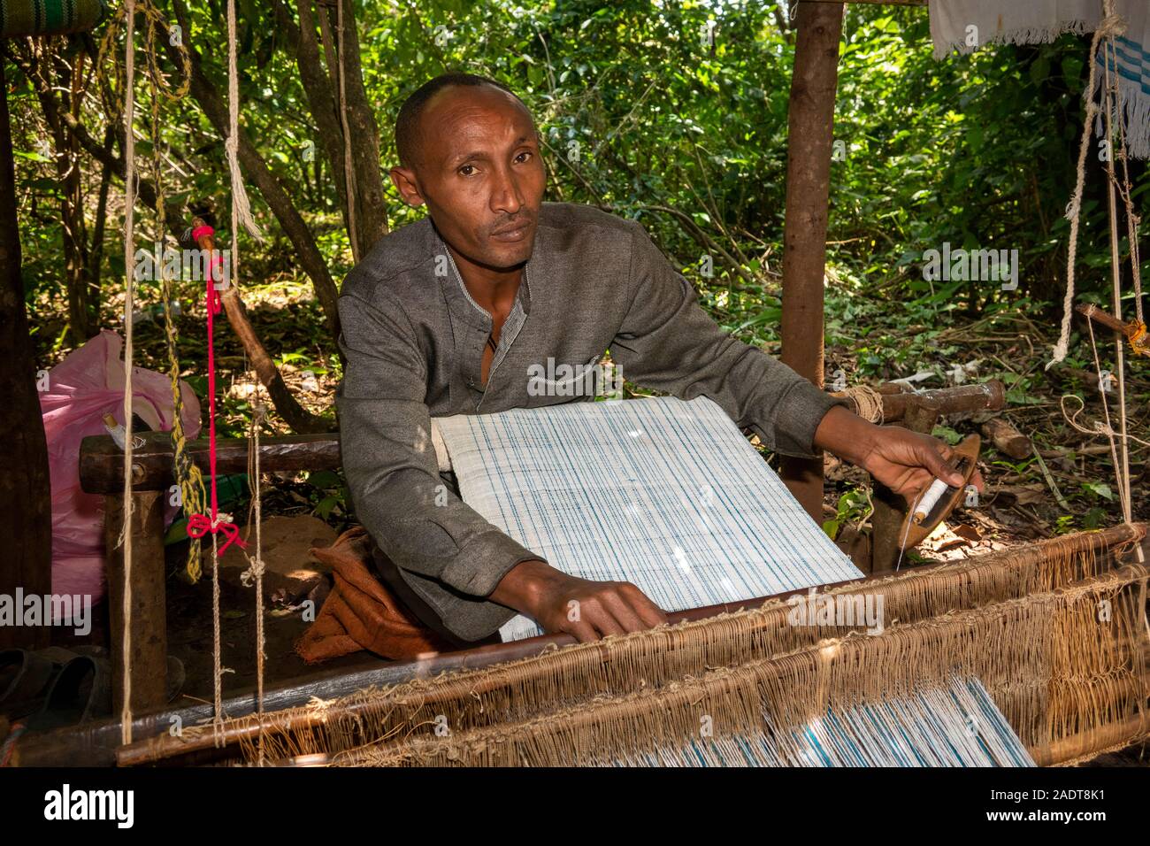 Ethiopia, Amhara Region, Bahir Dar, Lake Tana, Zege Peninsula, man weaving cloth for souvenir stall Stock Photo
