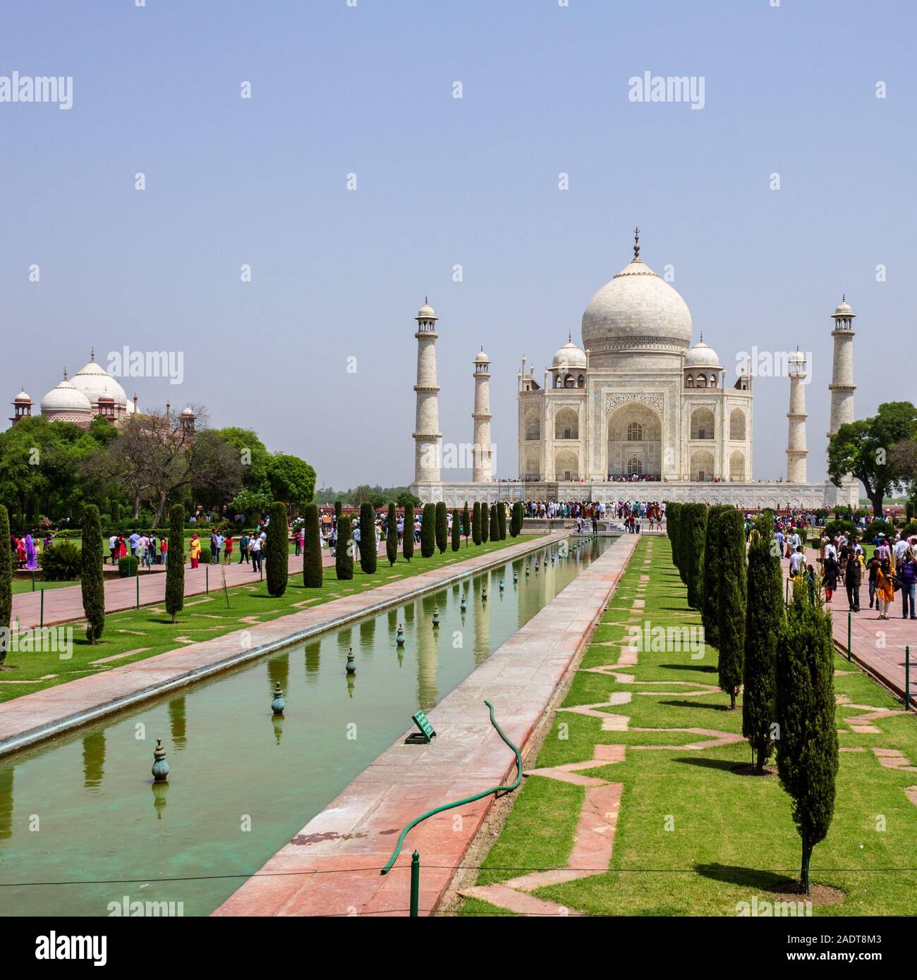 View on Taj Mahal with walkway, garden square, reflecting pool and visitors. UNESCO World Heritage in Agra, Uttar Pradesh, India Stock Photo