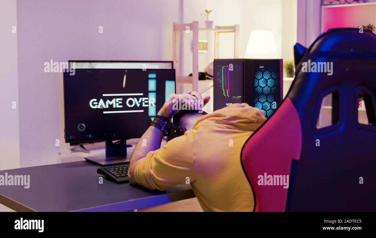 Man In A Room With Colorful Neon Lights Sitting On Gaming Chair