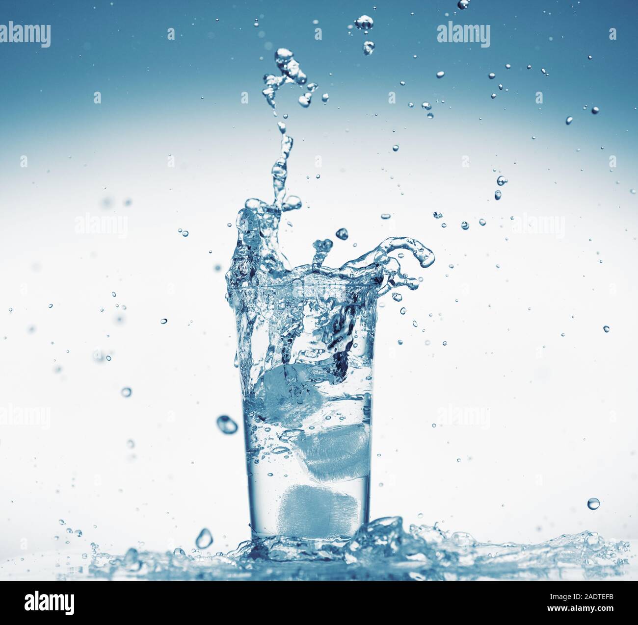 one glass of water with splash from falling ice cube, white background ...