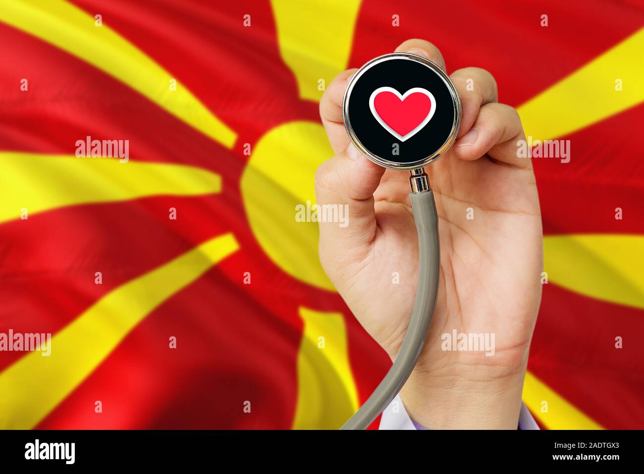 Doctor holding stethoscope with red love heart. National Macedonia flag