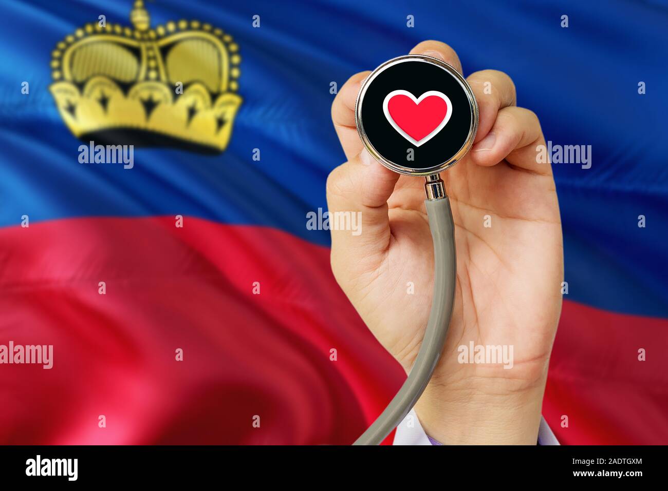 Doctor holding stethoscope with red love heart. National Liechtenstein flag background. Healthcare system concept, medical theme. Stock Photo