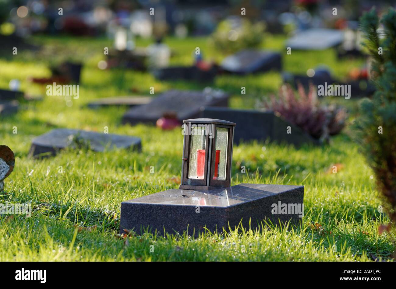 lantern on a gravestone of a cemetery with pauper graves against blurred background Stock Photo
