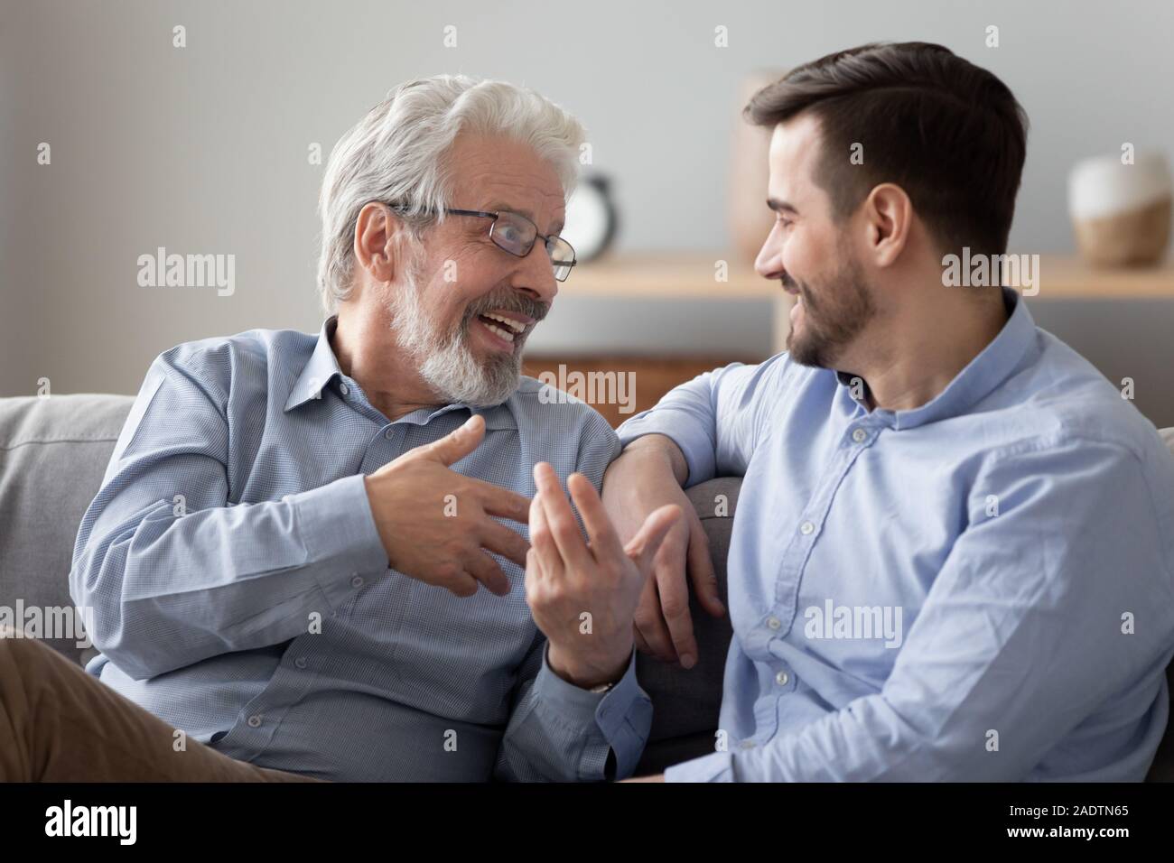 Aged father talking with grownup son family sitting on couch Stock ...