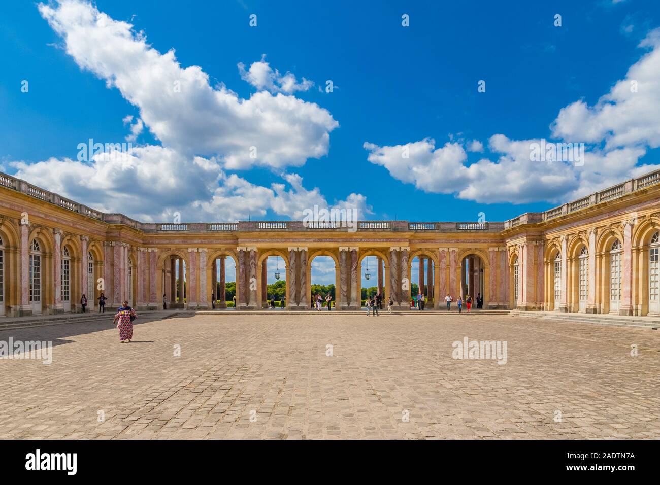 Lovely panoramic view of the cobbled stone courtyard and the sheltered colonnade connecting the two wings of the famous Grand Trianon Palace in... Stock Photo