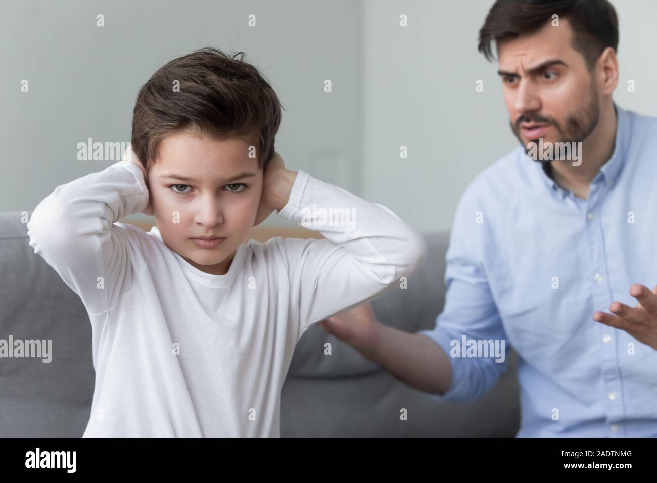Angry strict father shouting screaming at little son at home Stock Photo